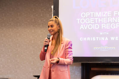 Close-up of Christina Weber confidently speaking with microphone at Beyond Biohacking Conference