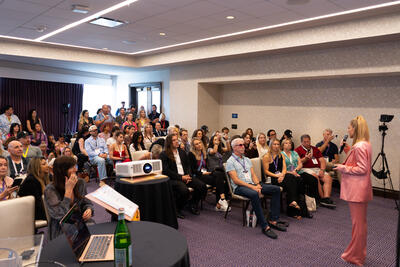 Wide shot of Christina Weber addressing a packed audience at Beyond Biohacking Conference