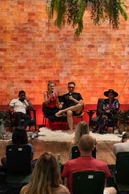 Christina Weber speaking with microphone during a panel discussion at Day of Biohacking Love