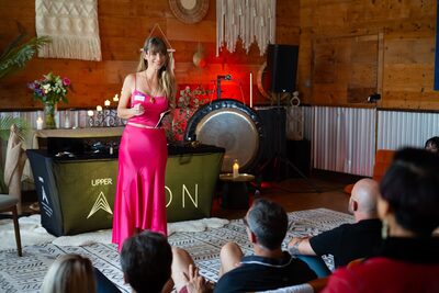 Christina Weber on stage beside the gong at Biohacking Love at Upper Aeon