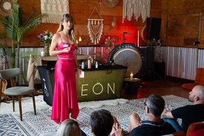 Christina Weber in pink satin dress welcoming the audience at Biohacking Love