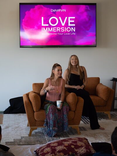 Christina Weber in conversation beneath the Love Immersion screen at a WeDeepen event