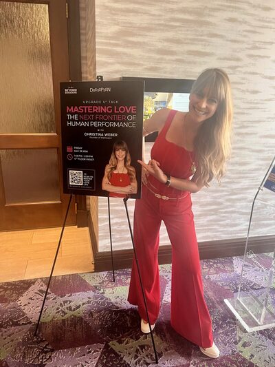Christina Weber with her Mastering Love: The Next Frontier of Human Performance keynote poster at Beyond Biohacking Conference