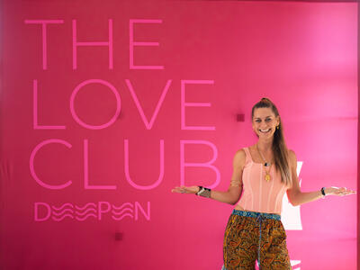 Christina Weber presenting next to Love Club banner at June 2025 Love Immersion