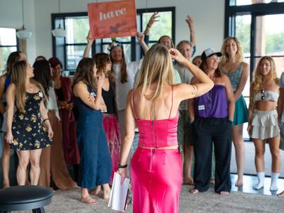 Christina Weber with arms raised leading a group at Love Immersion V