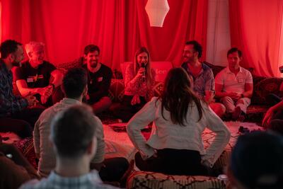 Christina Weber with microphone facilitating an intimate circle at MediDating