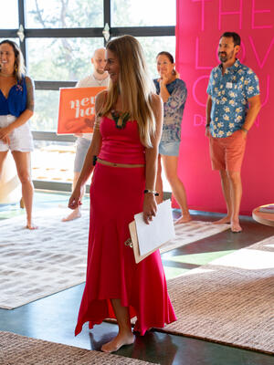 Christina Weber leading a group exercise at September 2025 Love Immersion with WeDeepen banners